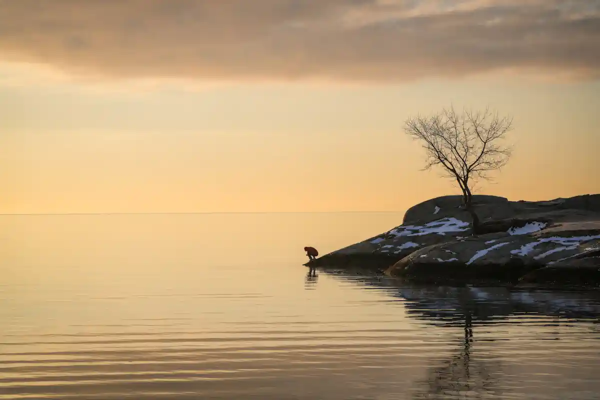 lake with golden sky and a stone shore