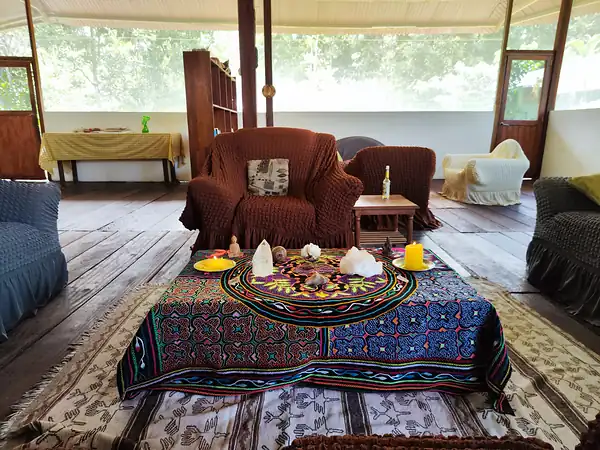 A low altar table set with crystals and a candle on an embroidered cloth.