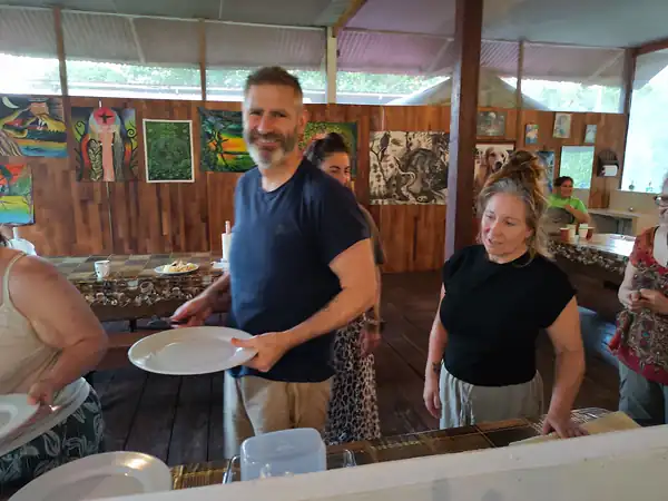 Guests collecting plates at the buffet in the dining hall, its walls hung with paintings.